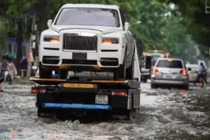 xe rolls royce bị ngập nước đang được xe cứu hộ chở về